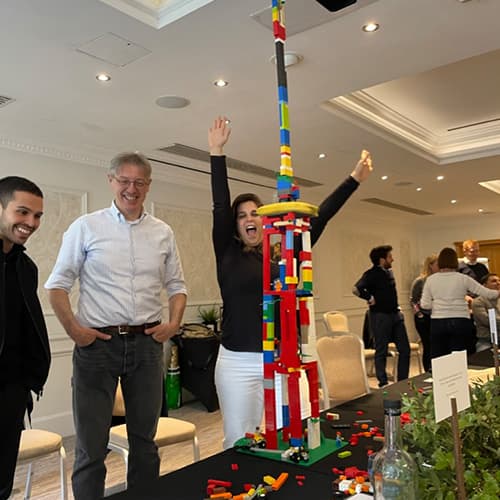 Group celebrating their large lego tower during a Lego Serious Play workshop.